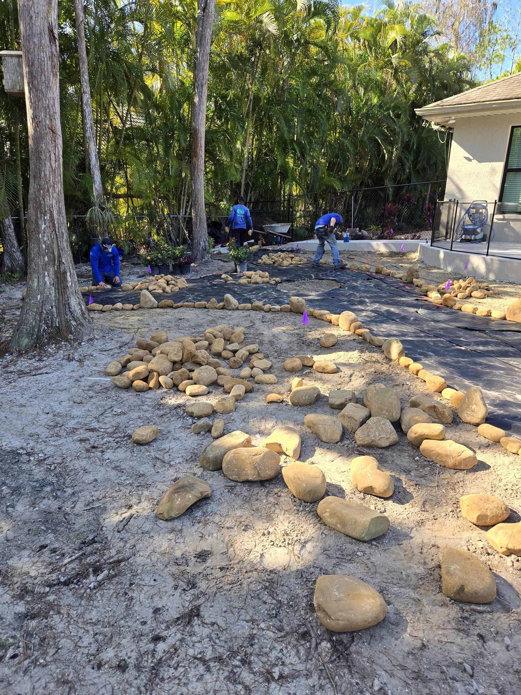 Landscape installation underway with stone borders being placed